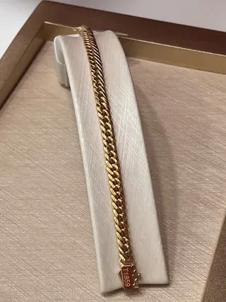 نمای نزدیک دستبند کارتیه ژاپنی لایت طلا با زنجیره بافت‌دار روی پایه سفید