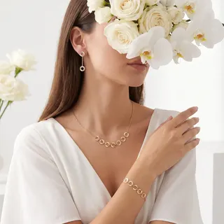 نمایی از سرویس طلای زنانه سارن با طراحی ظریف حلقه‌ای شامل گردنبند، دستبند و گوشواره در استایل زنانه